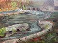 Painting of a landscape with trees and water on a wooden surface