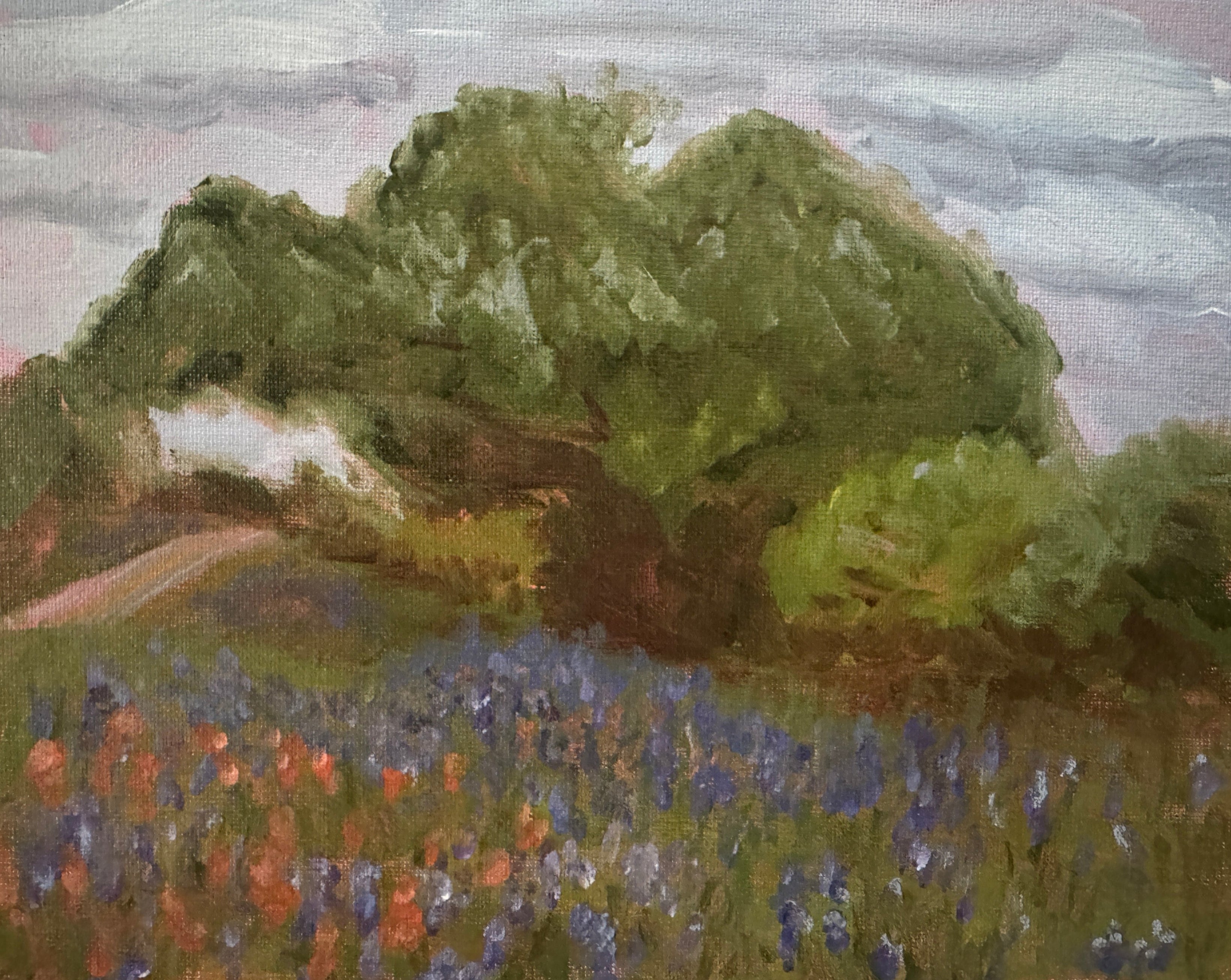 Painting of a landscape with green hills and blue flowers on a textured surface.