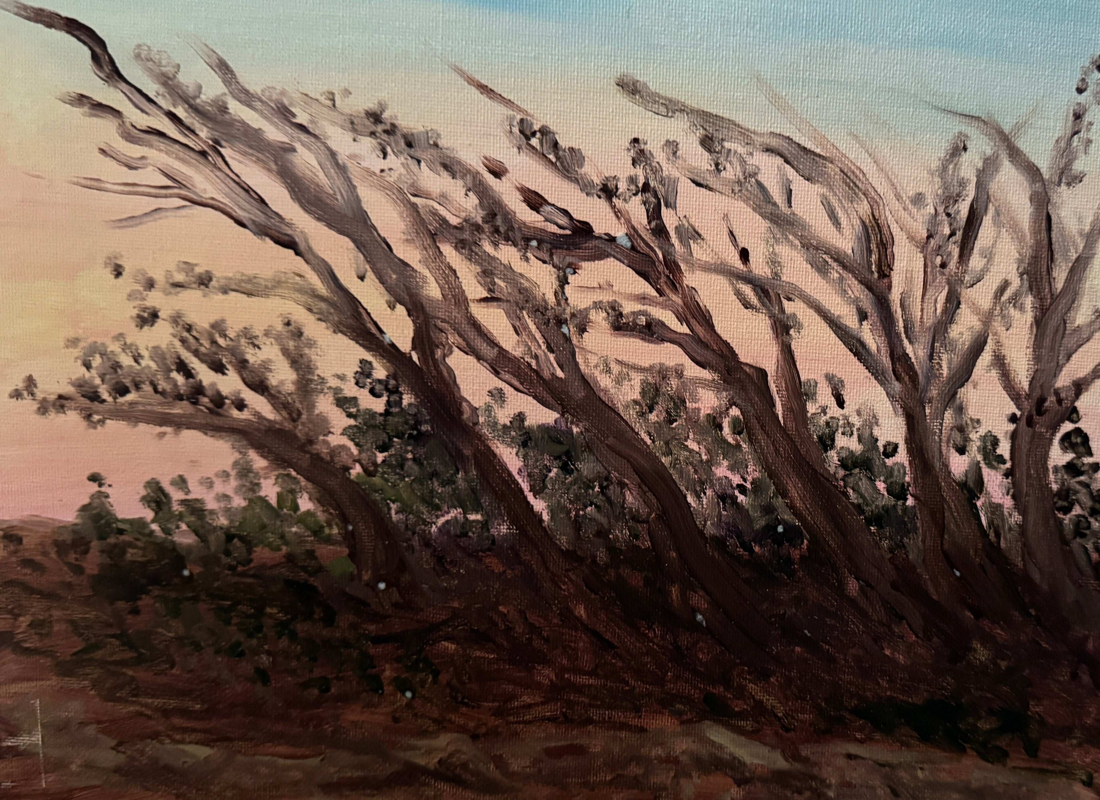 Painting of a landscape with trees and a sunset on a stone surface