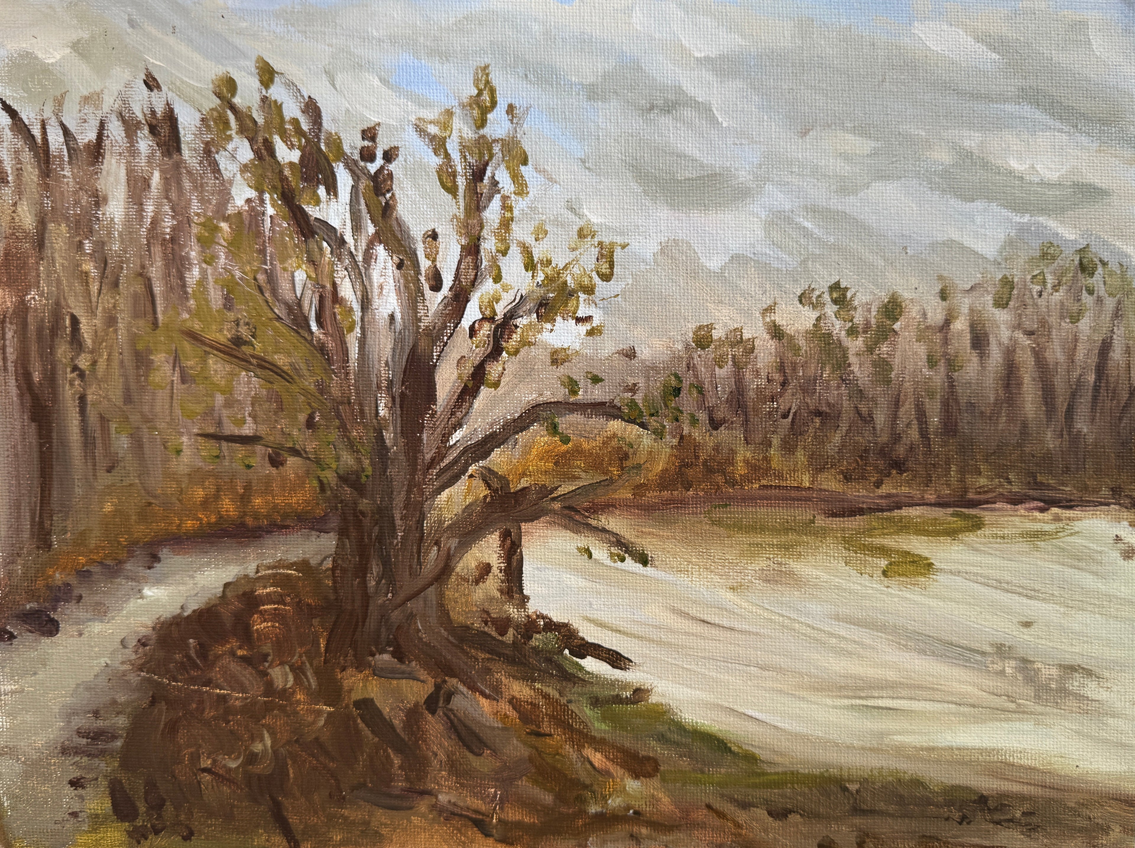 Painting of a landscape with a tree and field on a wooden surface
